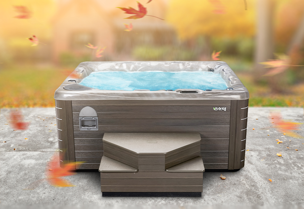 hybrid4 hot tub in a backyard with falling orange leaves around it